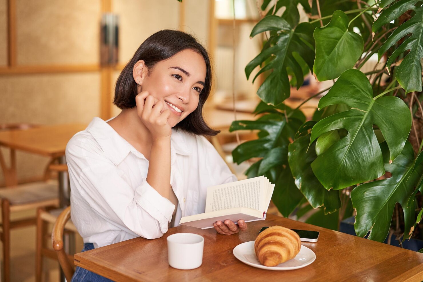 カフェでコーヒーを楽しむ女性の写真